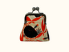 kisslock coin purse printed with a flame-backed fiddler crab pattern in black and red-orange against a wavy beige background, with a mid-century modern feel