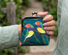 Gouldian finch purse held in a hand