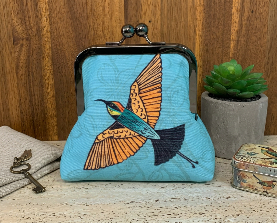 kisslock purse with rainbow bee eater design on a blue background