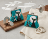 Two large kisslock coin purses featuring stylised black, grey and white cats against a full moon on a turquoise background