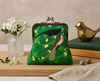Large kisslock purse featuring a pair of Eastern koels in a white fig on a green background