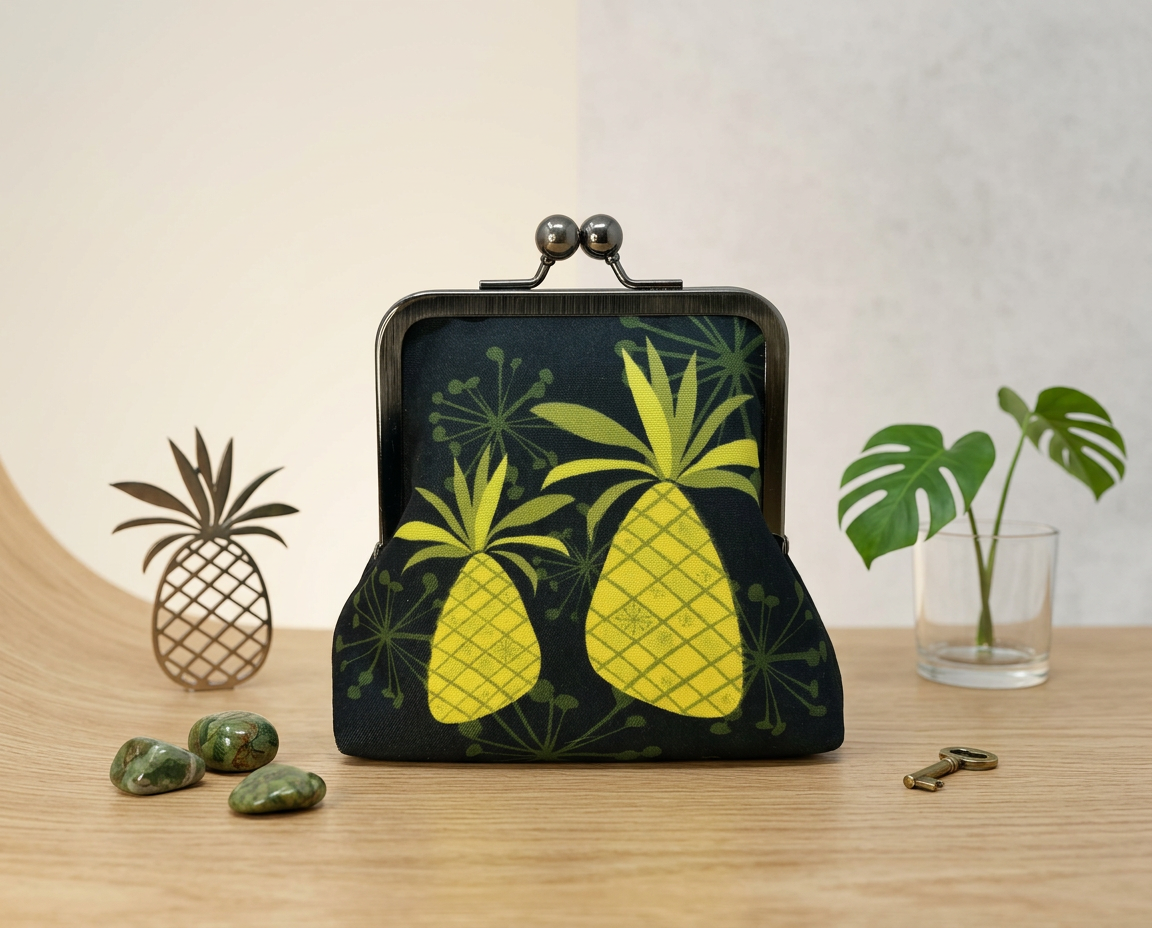 large kisslock purse with two bright mid-century modern inspired pineapples on a black background