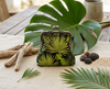 large kisslock coin purse featuring tropical leaves on a black background