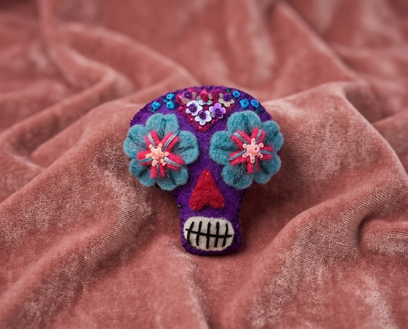 Hand-stitched felt sugar skull brooch in purple, blue and pink