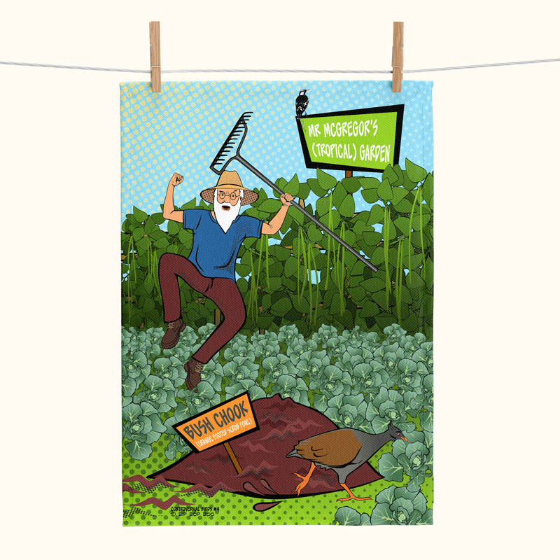 linen tea towel printed with a comic style picture of a man shaking a rake at an orange-footed scrub fowl that is digging up his garden