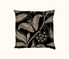 cushion with beige pattern of Atlas moth and Atlas Croton on a black background