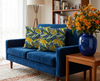 cushions patterned with stylised blue faced honeyeaters and scarlet gum blooms on a blue couch in a lounge room