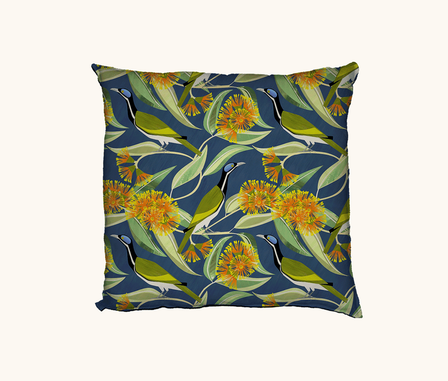 cushion patterned with stylised blue faced honeyeaters and scarlet gum blooms