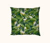 cushion featuring a stylised pattern of yellow and white flowers on green leaves and a teal background based on the tamanu tree