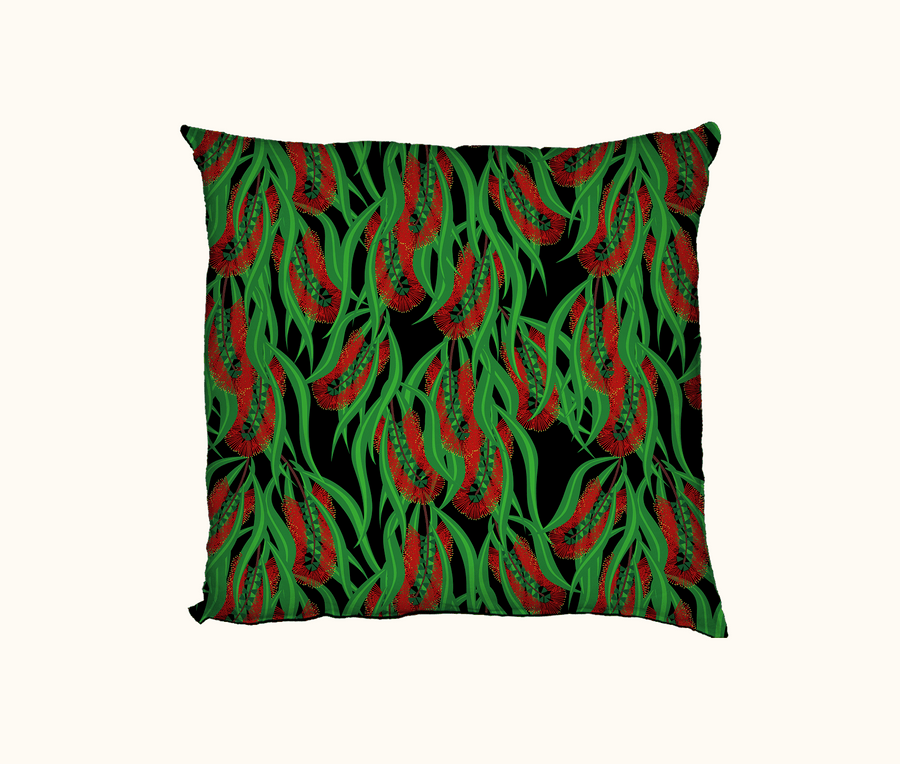 cushion with red callistemon flowers and green leaves on a black background