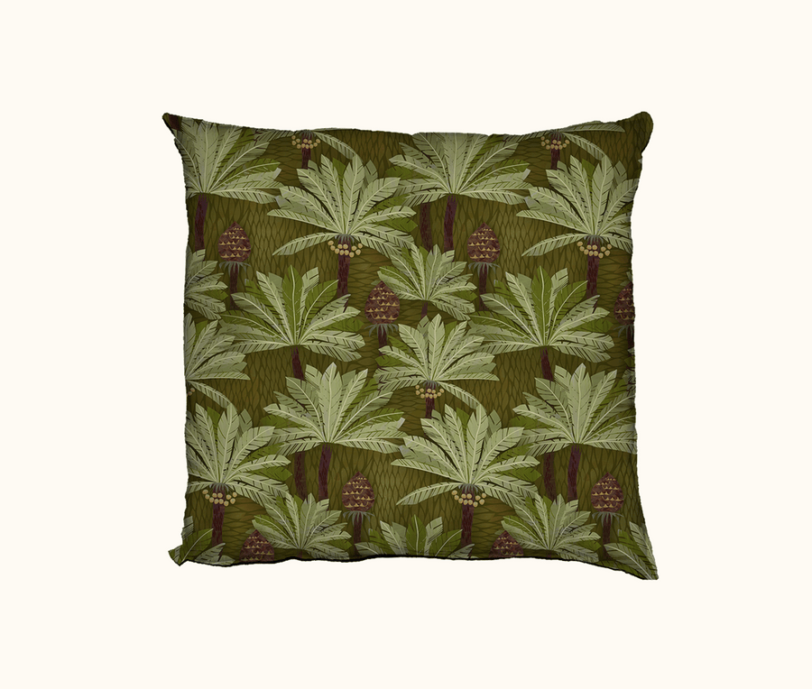 cushion with a pattern of cycads against a leaf textured background