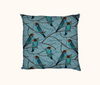 cushion with pattern of dollarbirds perched on twigs against a blue background