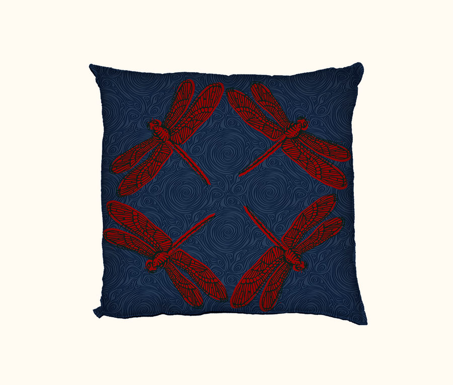 cushion with four large red dragonflies facing  out towards the corners on a dark blue swirly background