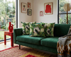 cushions featuring kookaburra in a river red gum in flower on a dark green background on green couch
