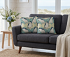 cushion printed with a repeat pattern of little penguins against a pale blue-green and sand coloured ogee design