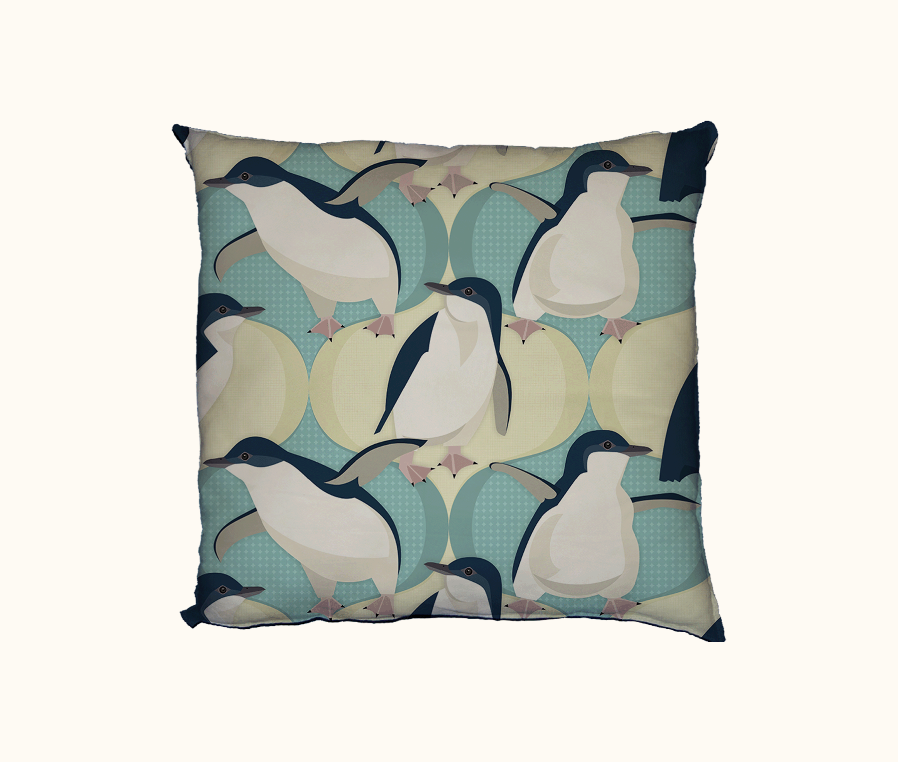 cushion printed with a repeat pattern of little penguins against a pale blue-green and sand coloured ogee design