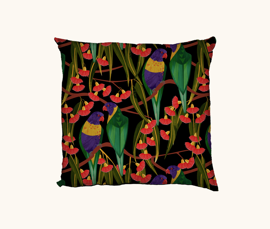 Cushion featuring rainbow lorikeets in a gum tree on a black background