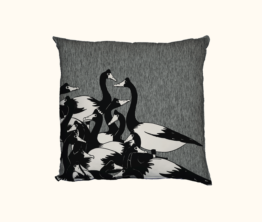 cushion with cluster of black and white magpie geese against a mottled background