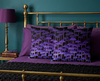 cushions featuring rows of purple mushrooms against a black background on a brass bed with purple sheets