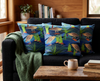 cushions featuring stylised Nankeen night heron, reeds and pandanus against a blue background suggestive of water on a couch in a loungeroom