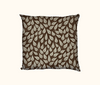 cushion patterned with stylised tufted grass heads against a brown spotted background