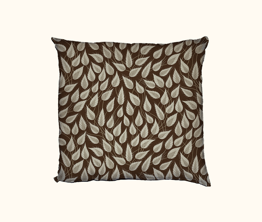 cushion patterned with stylised tufted grass heads against a brown spotted background