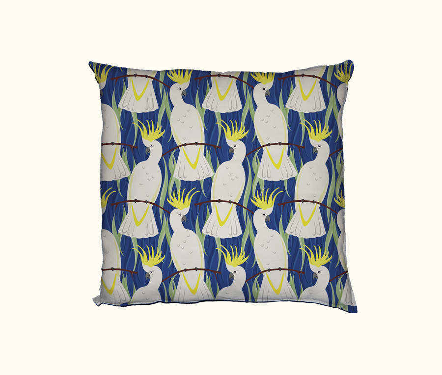 cushion with a pattern of stylised sulphur-crested cockatoos on a blue background