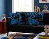 cushion with stylised red-tailed black cockatoo heads on a background of large red spots on a black couch