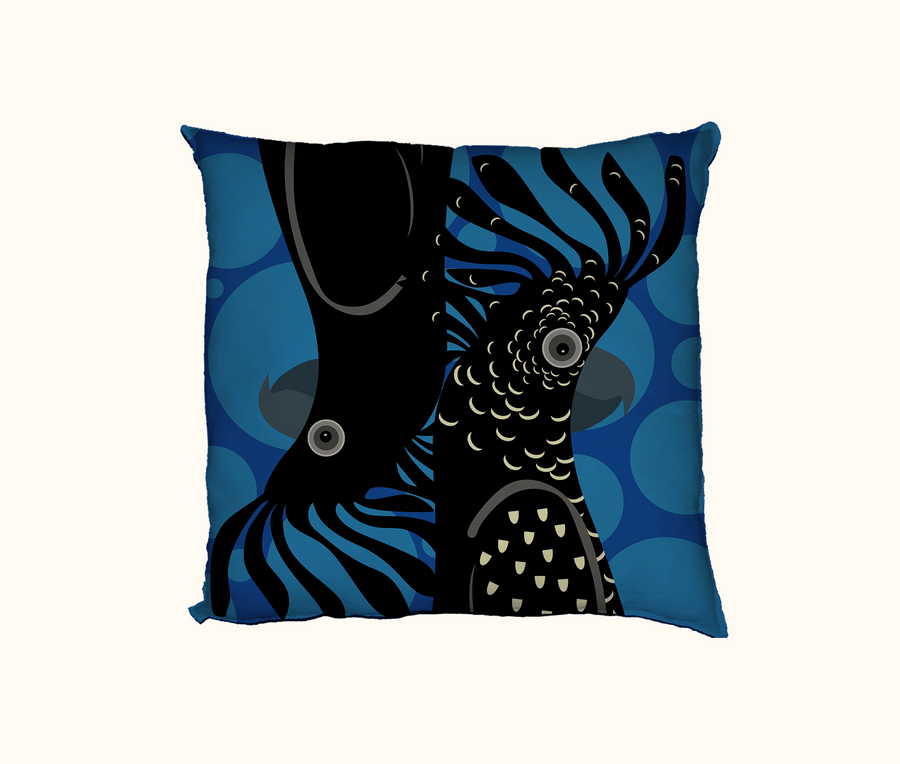 cushion with stylised red-tailed black cockatoo heads on a background of large red spots