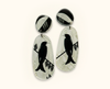 acrylic earrings featuring spangled drongos in black and white