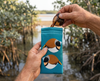 Canvas glasses slip case featuring two very round stylised chestnut breasted mannikins on a blue background being held by a man who is pulling a pair of glasses out of the case against a mangrove backdrop