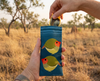 Canvas glasses slip case featuring two very round and highly stylised star finches on a blue background. A pair of yellow glasses are being removed from the pouch against a grassland backdrop.