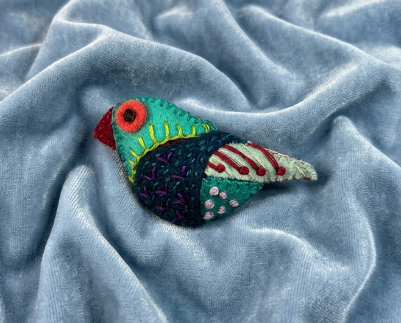 felt bird brooch in blues and greens with red highlights