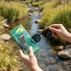 Canvas glasses slip case featuring a stylised black bittern standing on a rock in a stream.