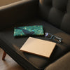 Canvas glasses slip case featuring stylised black butcherbird on a background of mottled sea-green leaves