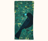Canvas glasses slip case featuring stylised black butcherbird on a background of mottled sea-green leaves