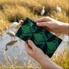 Canvas glasses slip case featuring a silhouette of facing dancing brolgas in an art nouveau inspired pattern in forest green