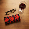 Canvas glasses slip case with black silhouette of brolgas dancing in an art nouveau inspired pattern in hot red and orange tones.