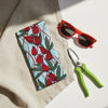 Canvas glasses slip case with a pale blue background and red rosella blossoms and leaves