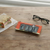 Canvas glasses slip case featuring a white ibis poking its head up behind four metal rubbish bins lined up against a red brick wall.