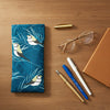 Canvas glasses slip case featuring stylised double barred finches and blue stalks on feathery grass on a blue background.