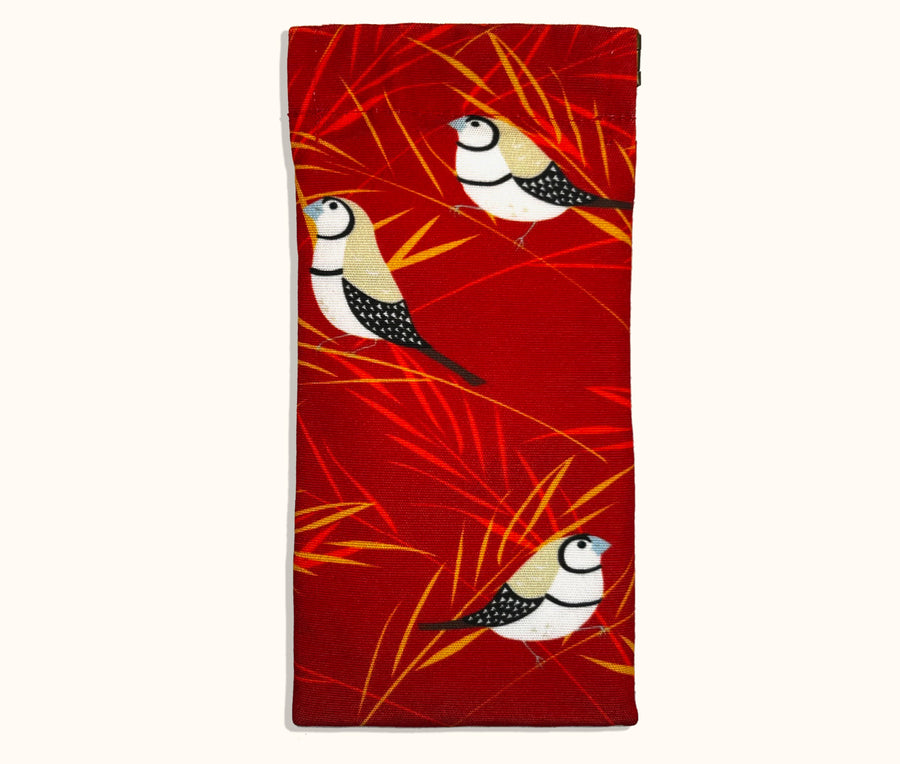Canvas glasses slip case with stylised double barred finches with red and gold grasses on a red background