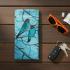A canvas glasses slip case featuring an illustration of two oriental dollar birds on a blue background with branch patterns.