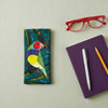 Canvas glasses slip case featuring one stylised gouldian finch on a branch against a leafy teal and green background