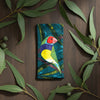 Canvas glasses slip case featuring one stylised gouldian finch on a branch against a leafy teal and green background