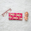 Canvas glasses slip case covered in red mushrooms with white spots on a dark teal green background.
