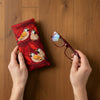 Canvas glasses slip case featuring long tailed finches against a backdrop of red leaves