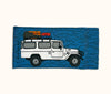 Canvas glasses slip case featuring a troop carrier with a loaded roof rack on a blue mottled background