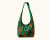canvas shoulder bag with red callistemon flowers and green leaves on a black background
