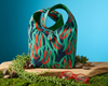 canvas shoulder bag with red callistemon flowers and green leaves on a black background